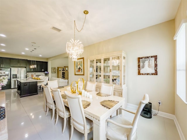 dining area featuring light tile patterned floors, a notable chandelier, and sink