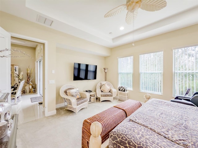 carpeted bedroom featuring a raised ceiling and ceiling fan