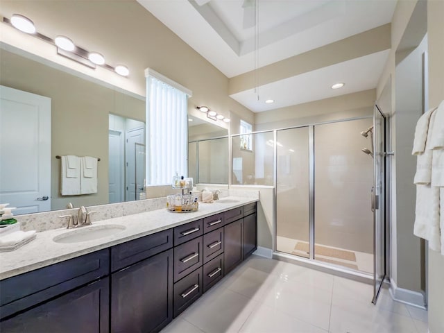 bathroom featuring a raised ceiling, vanity, tile patterned floors, and walk in shower