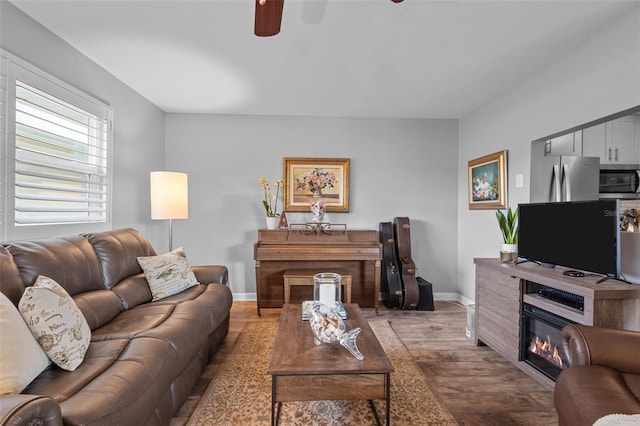 living room featuring wood-type flooring and ceiling fan