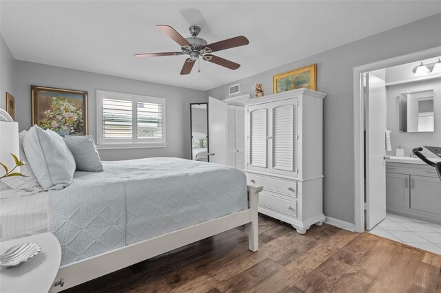 bedroom with connected bathroom, ceiling fan, and light hardwood / wood-style floors