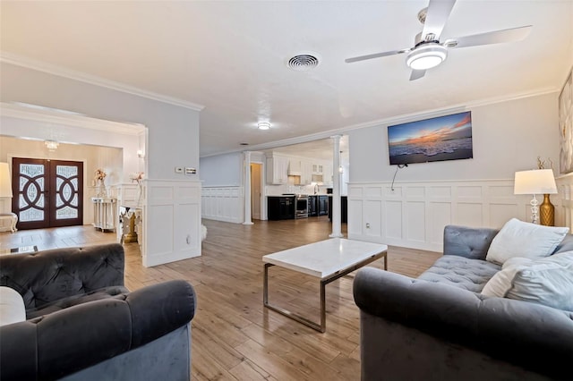 living room with crown molding, ceiling fan, light hardwood / wood-style floors, and french doors