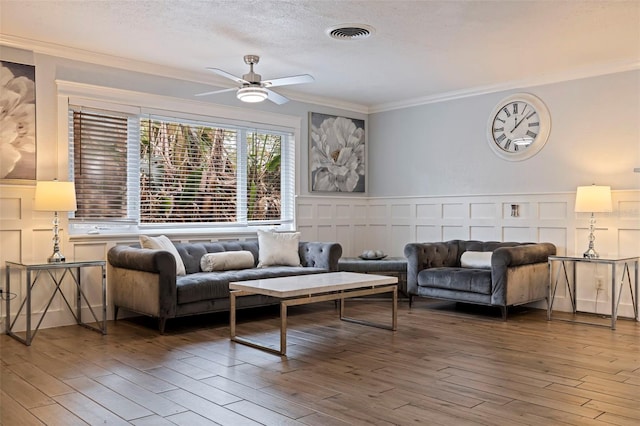 living room featuring crown molding, hardwood / wood-style floors, a textured ceiling, and ceiling fan