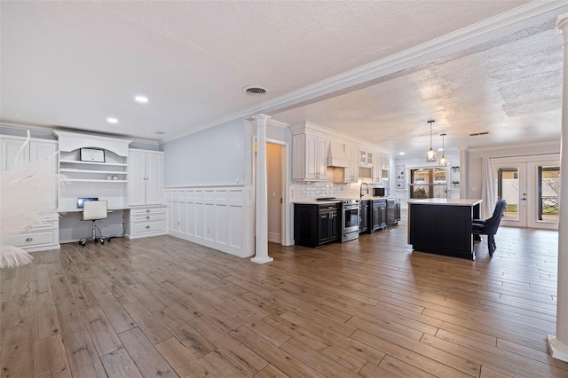 living room with crown molding, built in desk, a textured ceiling, and hardwood / wood-style flooring