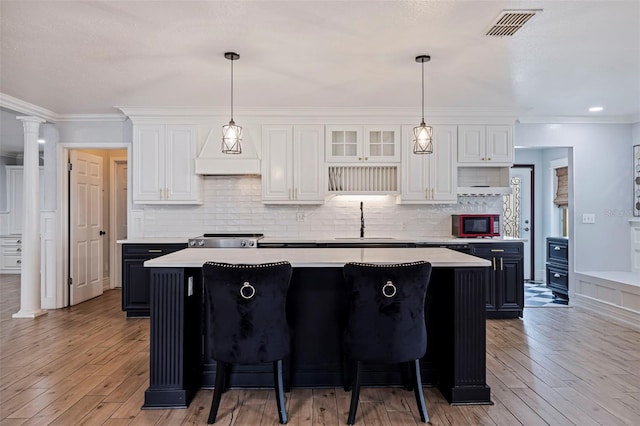 kitchen featuring sink, light hardwood / wood-style flooring, white cabinets, and a kitchen island