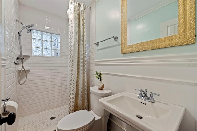 bathroom with sink, a shower with curtain, ornamental molding, and toilet