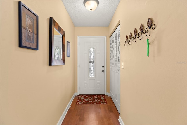 entryway with wood-type flooring and a textured ceiling