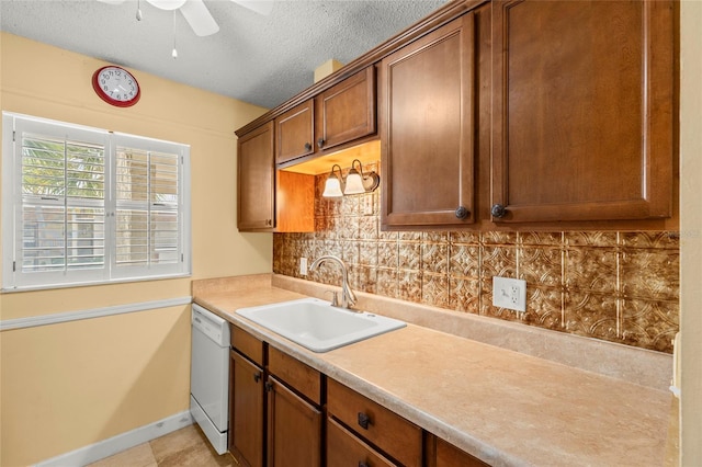 kitchen featuring backsplash, a textured ceiling, white dishwasher, ceiling fan, and sink