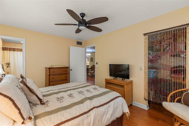 bedroom with hardwood / wood-style flooring, ceiling fan, and a textured ceiling