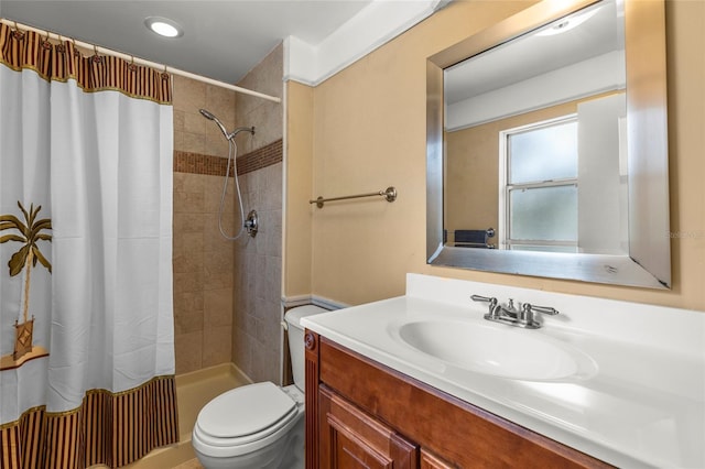 bathroom featuring toilet, vanity, and walk in shower