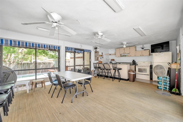 dining area featuring ceiling fan and light colored carpet