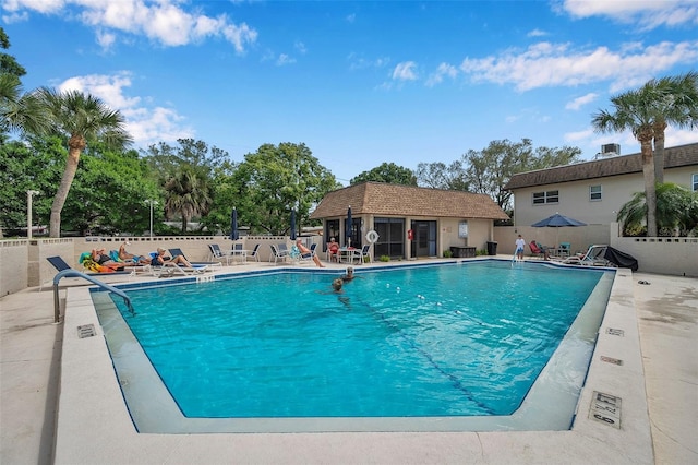 view of pool with an outbuilding and a patio