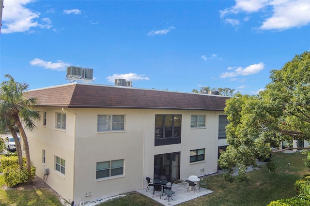 back of property with a lawn, a patio, and central AC unit