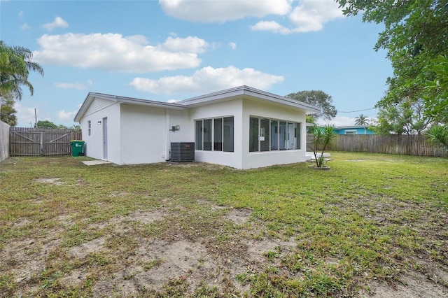 back of property featuring a lawn and cooling unit