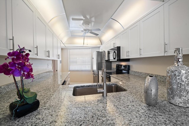 kitchen featuring sink, white cabinetry, light stone counters, ceiling fan, and black appliances