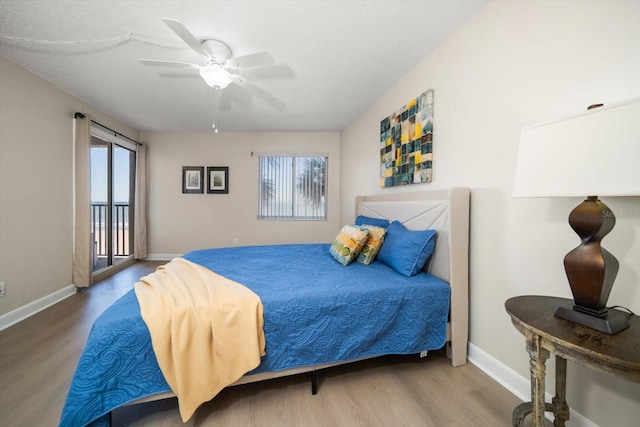 bedroom with multiple windows, wood-type flooring, and ceiling fan