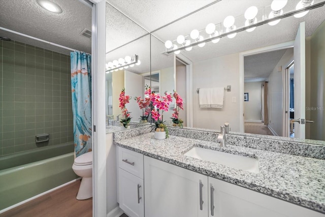 full bathroom with hardwood / wood-style flooring, vanity, a textured ceiling, toilet, and shower / bath combo with shower curtain