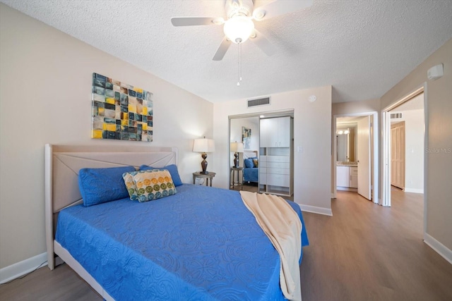 bedroom featuring wood-type flooring, a textured ceiling, and ceiling fan