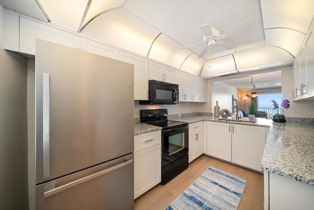 kitchen featuring black appliances, white cabinetry, ceiling fan, light hardwood / wood-style floors, and light stone countertops