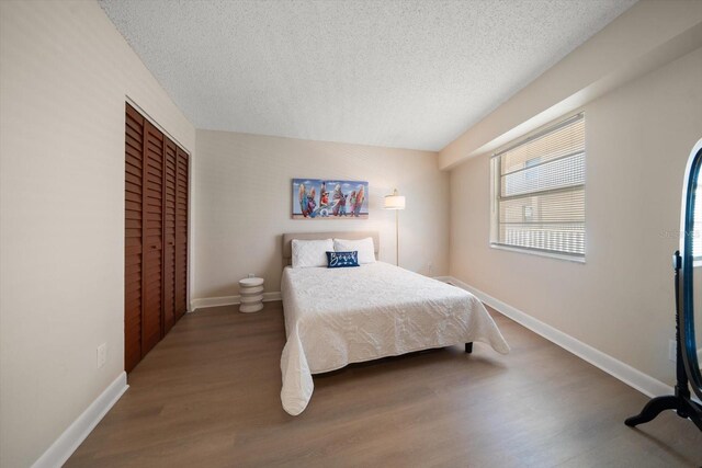 bedroom with wood-type flooring, a closet, and a textured ceiling