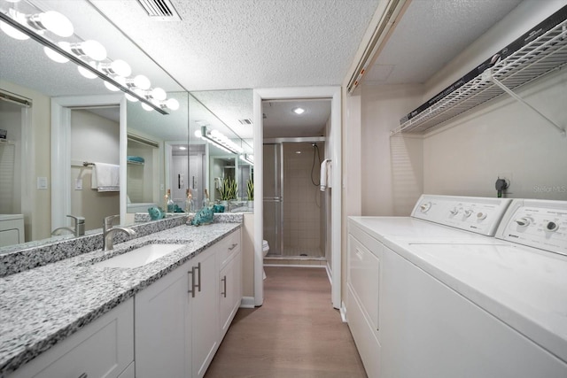 washroom featuring sink, wood-type flooring, and washer and dryer