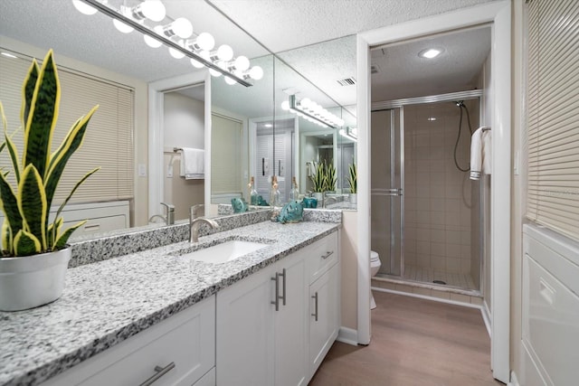 bathroom featuring vanity, wood-type flooring, walk in shower, and toilet