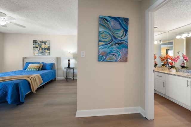 bedroom with light wood-type flooring, a textured ceiling, and ceiling fan