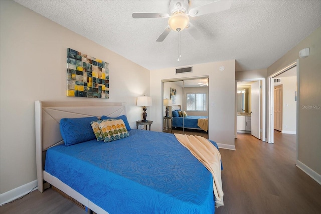 bedroom with hardwood / wood-style flooring, a textured ceiling, ceiling fan, and a closet