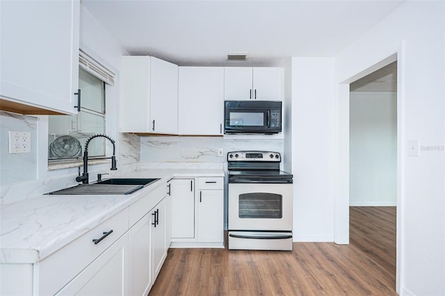 kitchen with tasteful backsplash, sink, electric range, white cabinets, and hardwood / wood-style floors