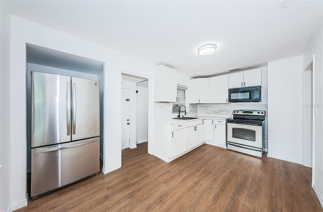 kitchen with range with electric stovetop, white cabinetry, sink, and stainless steel refrigerator