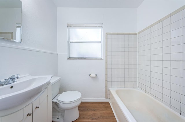 full bathroom with vanity, hardwood / wood-style flooring, toilet, and tiled shower / bath