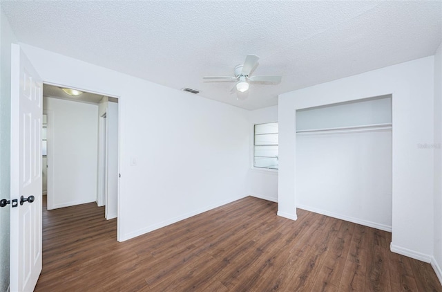 unfurnished bedroom featuring a textured ceiling, ceiling fan, a closet, and dark hardwood / wood-style floors