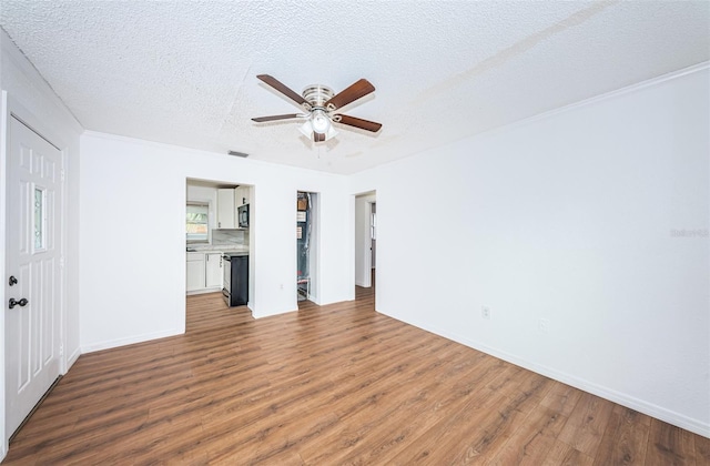 unfurnished living room featuring hardwood / wood-style flooring, ceiling fan, and a textured ceiling