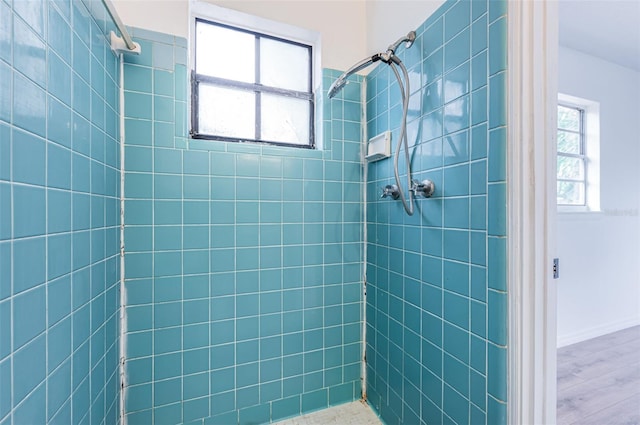 bathroom featuring hardwood / wood-style floors and tiled shower