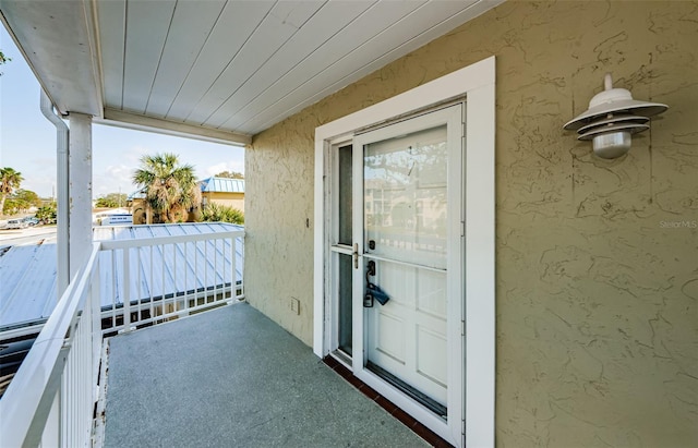 view of exterior entry featuring a balcony