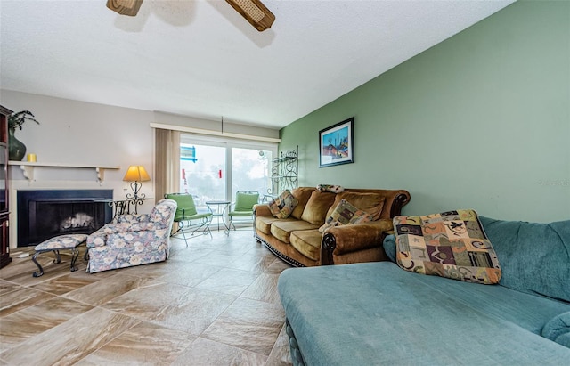 living room with ceiling fan and a textured ceiling