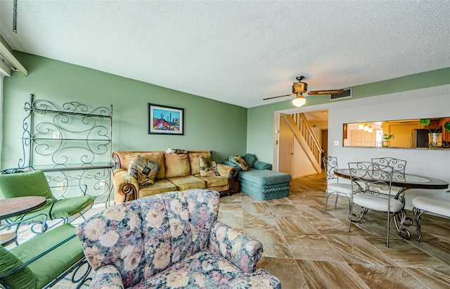 living room with ceiling fan and a textured ceiling