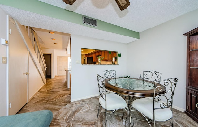 dining area featuring a textured ceiling and ceiling fan