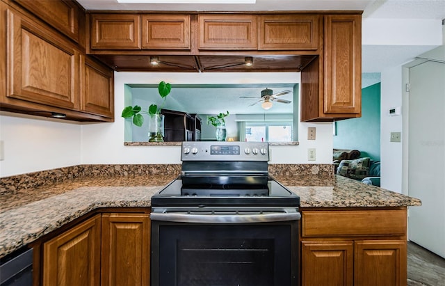 kitchen featuring ceiling fan, electric stove, and stone counters