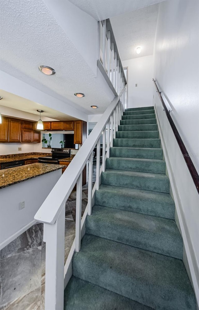 staircase with a textured ceiling