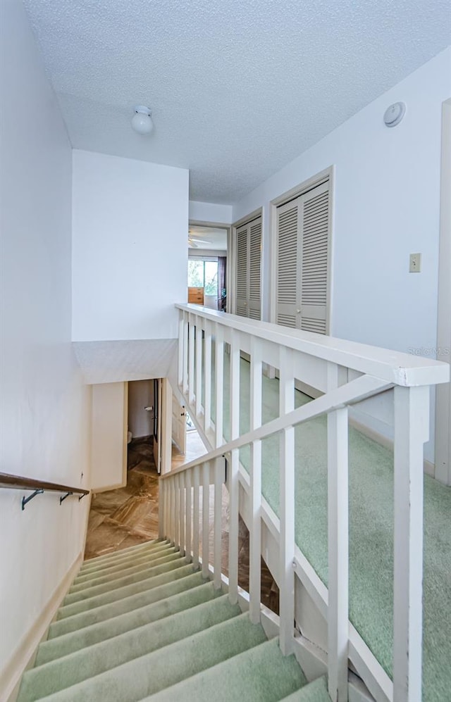 staircase with a textured ceiling