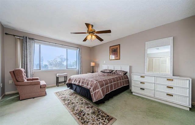 carpeted bedroom featuring a textured ceiling and ceiling fan