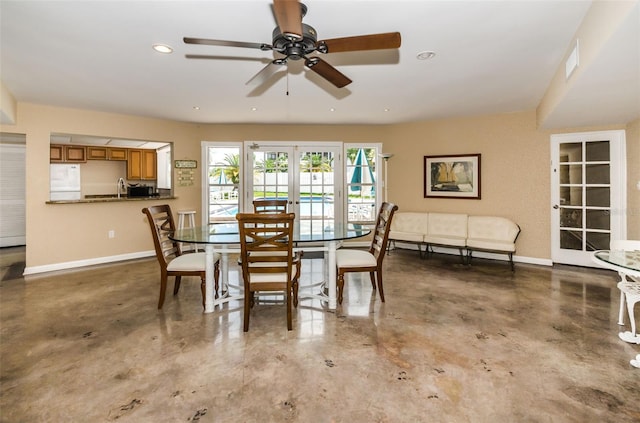 dining room with ceiling fan, french doors, and concrete floors