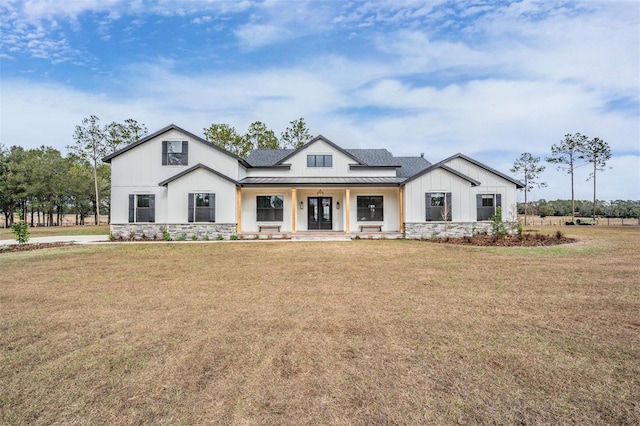 modern farmhouse style home with covered porch and a front yard