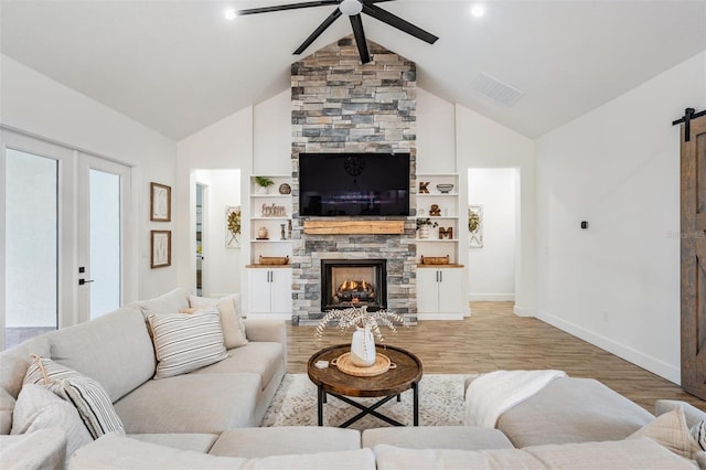 living room with ceiling fan, plenty of natural light, light hardwood / wood-style floors, and vaulted ceiling