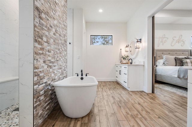 bathroom with vanity, independent shower and bath, and hardwood / wood-style flooring