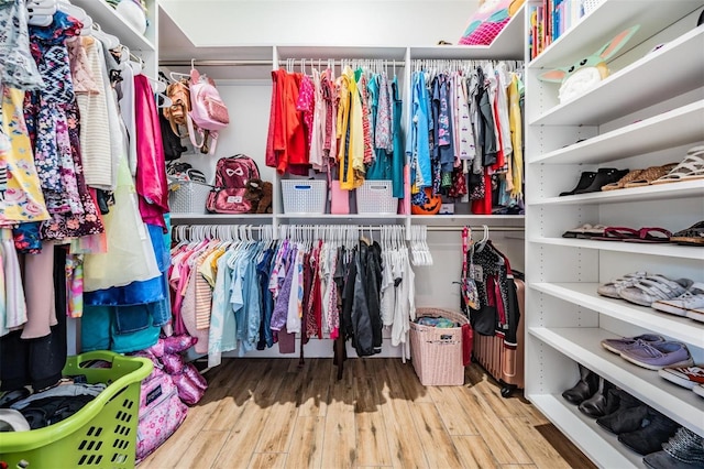 walk in closet with light hardwood / wood-style flooring