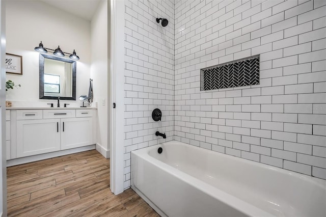 bathroom featuring hardwood / wood-style floors, tiled shower / bath combo, and vanity