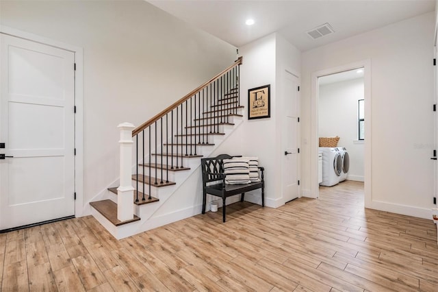 foyer entrance featuring light hardwood / wood-style flooring and washing machine and clothes dryer