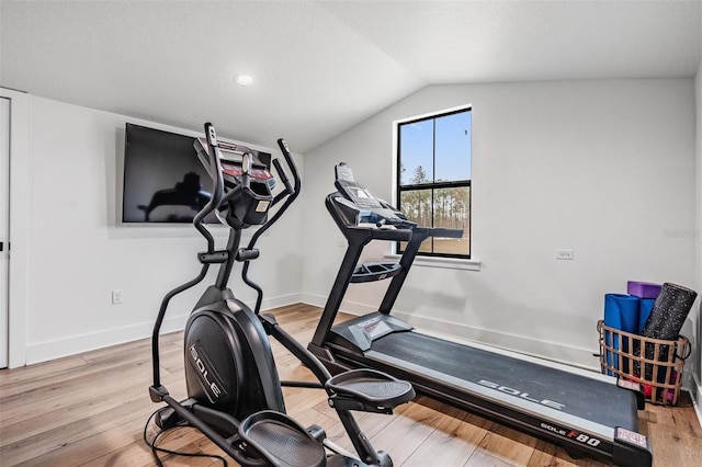 workout room featuring light hardwood / wood-style flooring and vaulted ceiling